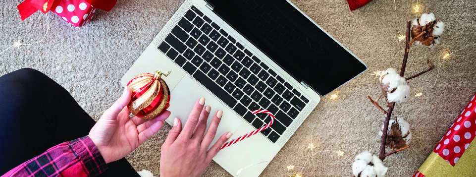 woman on a laptop with a Christmas ornament